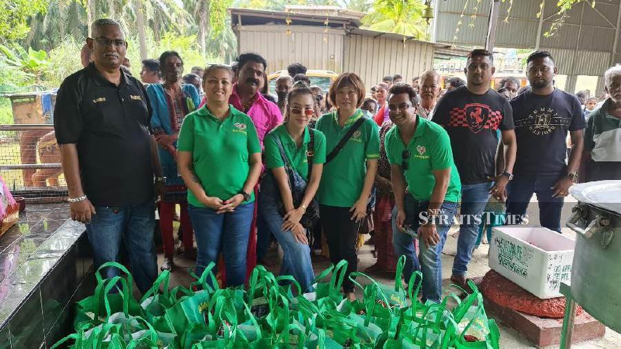 Poonam Singh (second from left) and her team from GHH hand over the groceries to needy families at the Sri Maha Sivagama Suntari Amman Alayam temple. Pix by VINCENT D’SILVA.
