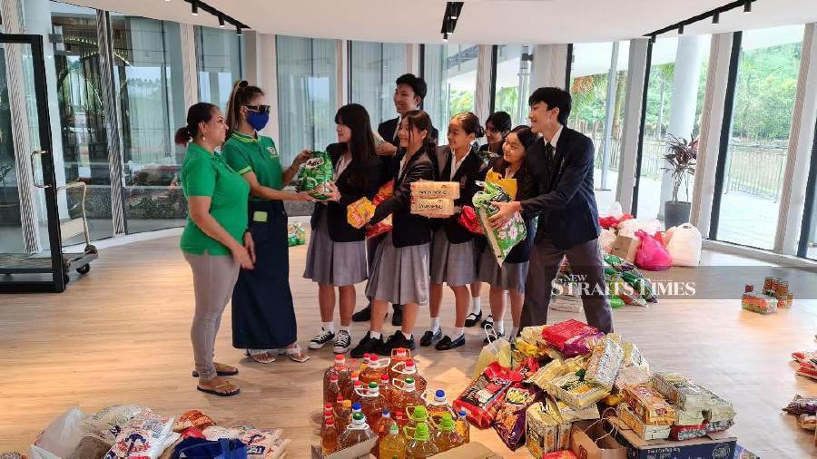 Students from Repton International School handing over the food items they collected from their peers to Poonam Singh (left). Pix by VINCENT D’SILVA.