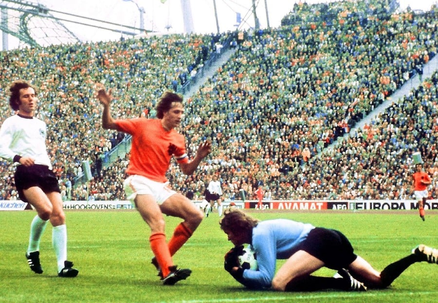 West German goalkeeper Sepp Maier catches the ball in front of Dutch forward Johan Cruyff as defender Franz Beckenbauer (L) looks on, July 7, 1974 in Munich, during the World Cup final. - AFP PIC