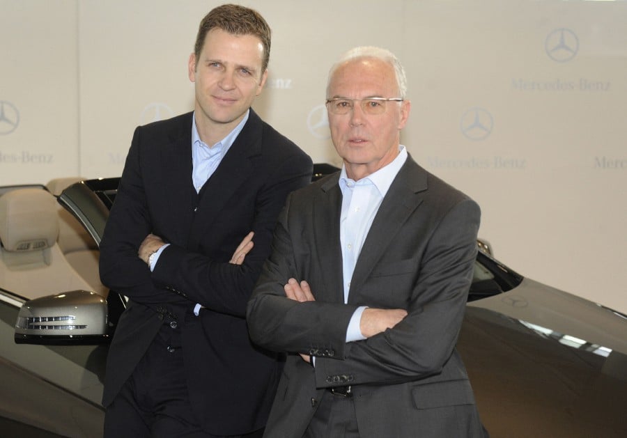  German football legend Franz Beckenbauer (R) and German football team manager Oliver Bierhoff pose with a Mercedes car during a media workshop organised by the German football association (DFB) to prepare the Football World Cup in South Africa, in Stuttgart January 28, 2010. - AFP PIC
