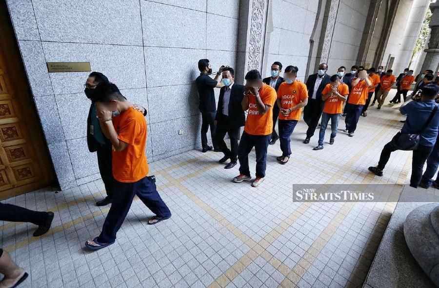 Clad in MACC's orange garb, they were then escorted to the first floor of the court for the remand process. - NSTP/MOHD FADLI HAMZAH.