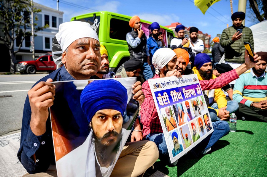 Raman Singh (L) holds a photo of Sikh organiser Amritpal Singh while protesting against the Indian government outside the Indian Consulate in San Francisco. -AFP PIC