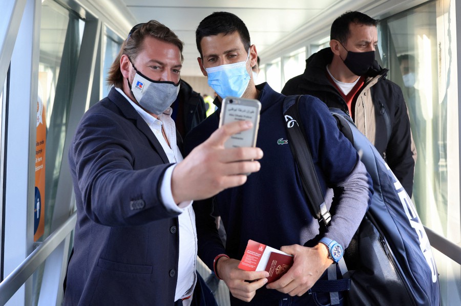 A man takes a selfie with Serbian tennis player Novak Djokovic as he arrives at Nikola Tesla Airport, after the Australian Federal Court upheld a government decision to cancel his visa to play in the Australian Open, in Belgrade, Serbia. - REUTERS PIC