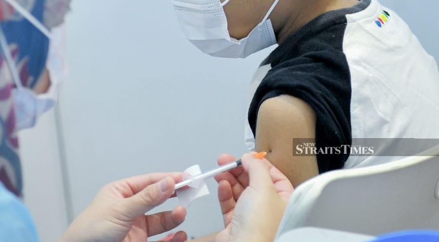 A medical officer helps administer Covid-19 vaccine on a child at the WTCKL in Kuala Lumpur. -NSTP/AIZUDDIN SAAD