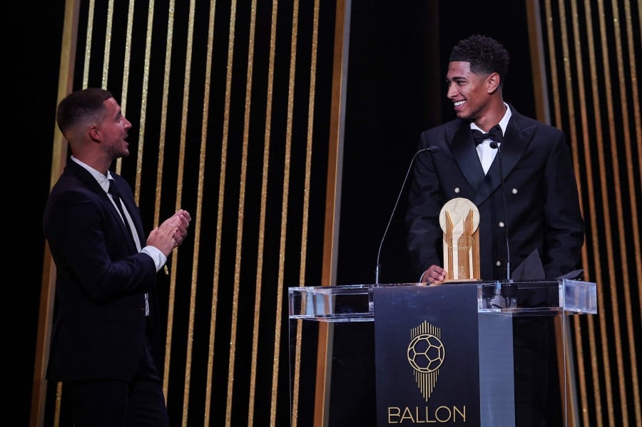 Real Madrid's English midfielder Jude Bellingham (R) reacts on stage as he receives the Kopa Trophy for best under-21 player next to former Belgian midfielder Eden Hazard during the 2023 Ballon d'Or France Football award ceremony at the Theatre du Chatelet in Paris. - AFP PIC