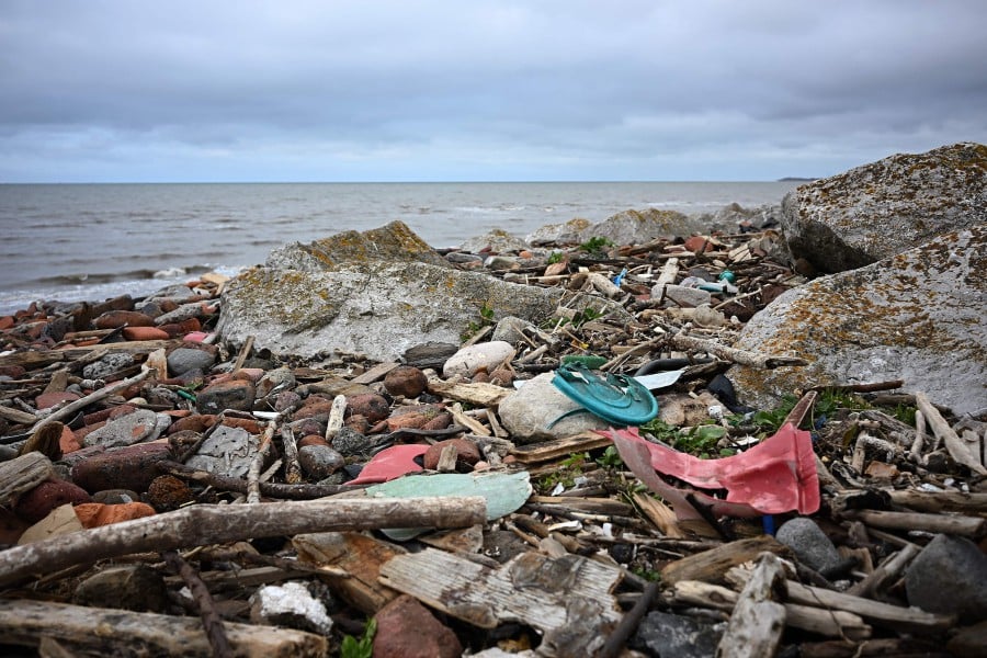 Rubbish including fragments of broken plastic items, rope, and plastic bags, is pictured, washed up on the shore from the sea, in Crosby, northwest England. - AFP PIC