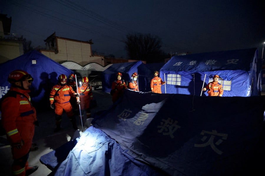 Rescue workers set up emergency tents at Kangdiao village following the earthquake in Jishishan county, Gansu province, China. - REUTERS PIC