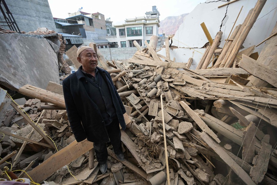  A man inspects a damaged building after an earthquake at Dahejia in Jishishan County in northwest China's Gansu province. - AFP PIC