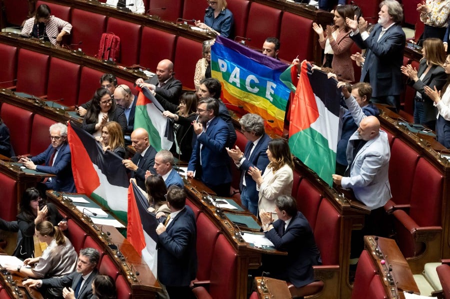 Several MPs from Italy's opposition Five Star Movement brandish five Palestinian flags and a peace flag in the lower Chamber of Deputies on May 28, 2024 in Rome's Montecitorio palace during a discussion on the Middle East crisis, as their colleague Riccardo Ricciardi speaks, calling on Italy to recognise the state of Palestine. - AFP PIC