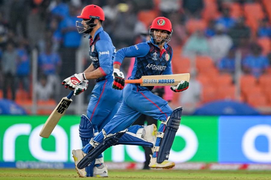 Afghanistan's Azmatullah Omarzai and Naveen-ul-Haq (L) run between the wickets during the 2023 ICC Men's Cricket World Cup one-day international (ODI) match between South Africa and Afghanistan at the Narendra Modi Stadium in Ahmedabad. - AFP PIC