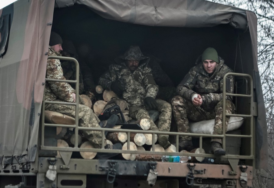 Ukrainian servicemen sit in a military vehicle as they transport wood for heating, amid Russia's attack on Ukraine, in Luhansk region, Ukraine. - AFP PIC