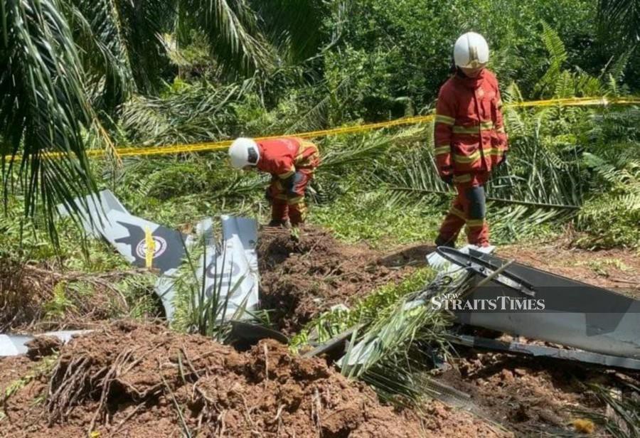 Rescuers inspecting the plane wreckage at Kg Tok Muda, Kapar following the crash. - Courtesy pic 