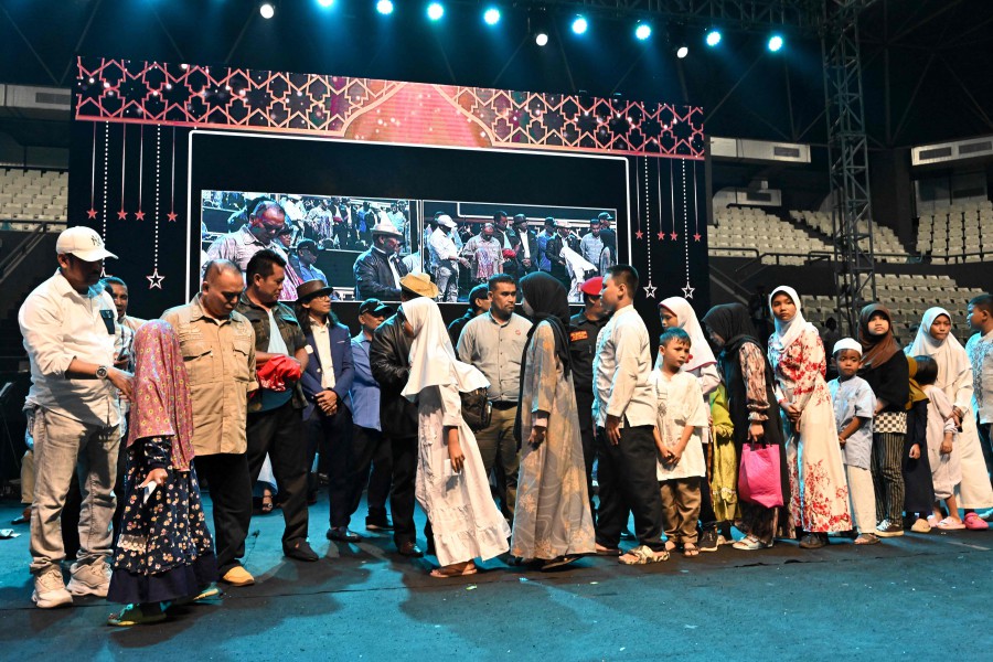 Orphans receive charities during an event of presidential candidate Prabowo Subianto and vice presidential candidate Gibran Rakabuming Raka at the Tennis Indoor Stadium Senayan in Jakarta. - AFP PIC