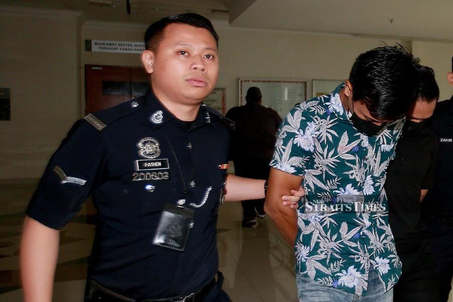 Mohamad Zainol Hafiz Mohamad Azmi is escorted after the trial at the Klang Session’s Court. -NSTP/FAIZ ANUAR