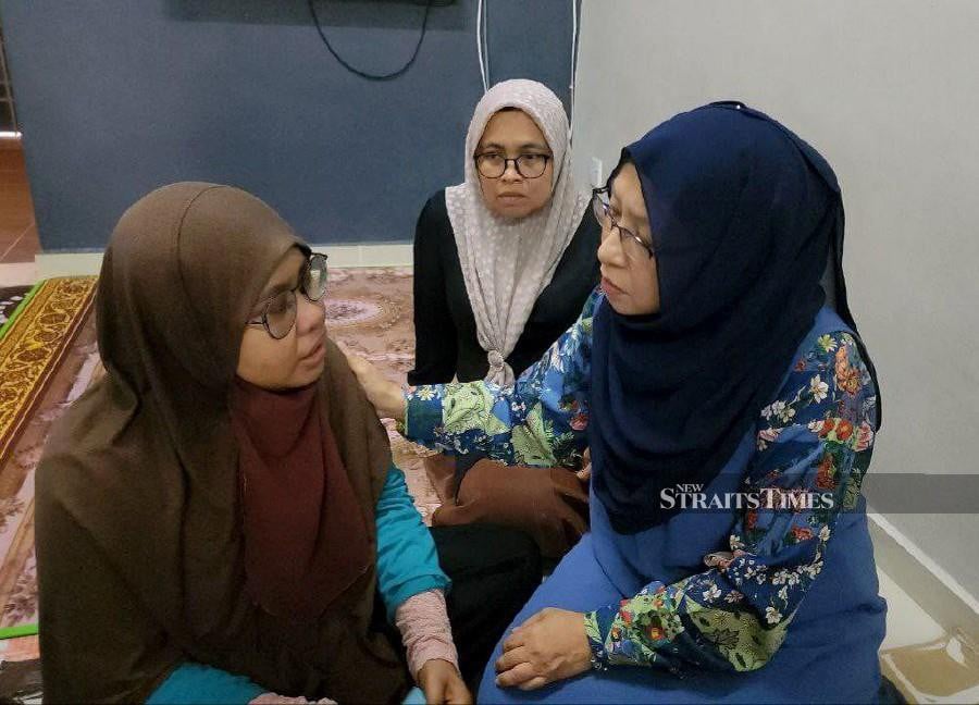 Cancer Survivors Malaysia (CSM) chairman Zuraini Kamal (right) comforts Umi Amira Mohd Dahalan (left), during a visit to the latter’s home in Sungai Petani. -NSTP/ZULIATY ZULKIFFLI