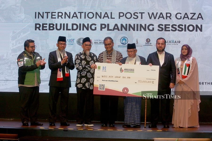 Health Minister Datuk Seri Dr Dzulkefly Ahmad (centre) accompanied by Malaysia Consultative Council of Islamic Organisations (MAPIM) president Mohd Azmi Abdul Hamid (3rd-right) receive the mock cheque from Well Asia Group Sdn Bhd chief executive officer Datuk Seri Abdul Majid Zainal Abidin (3rd-left) during the charity dinner for Gaza in Shah Alam. -NSTP/FAIZ ANUAR 