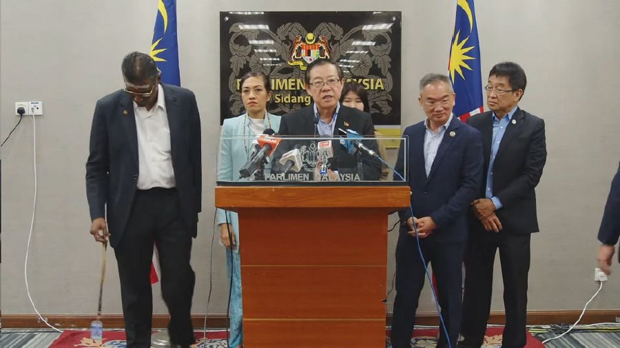 Lim Guan Eng (centre) accompanied by his fellow MPs, speak to the press during a press conference in Parliament. 
