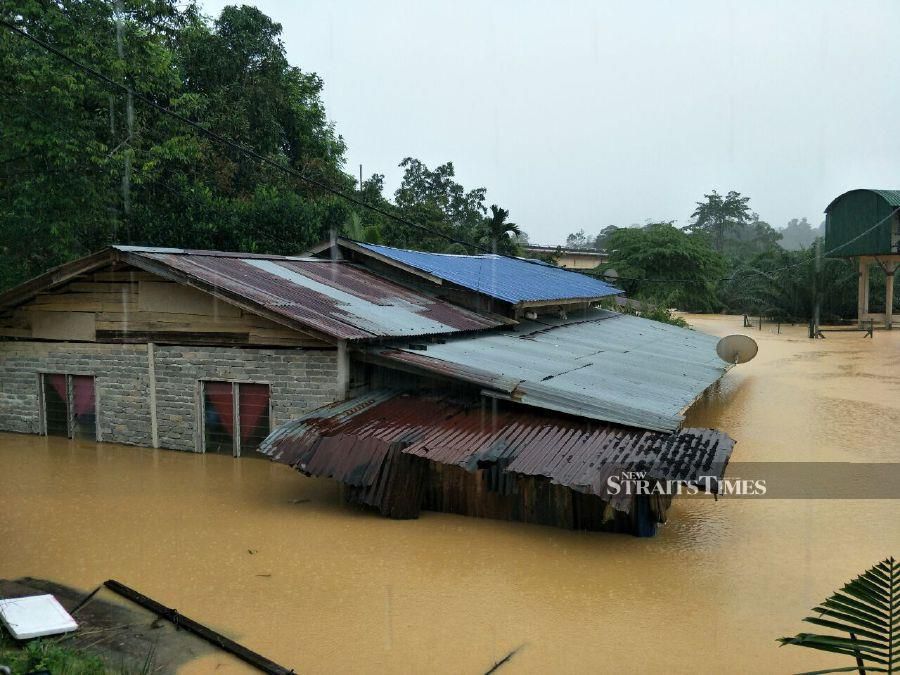 Houses near Sungai Galas in Kampung Limau Kasturi inudated with flood waters in Gua Musang. - NSTP/RAMLI IBRAHIM.