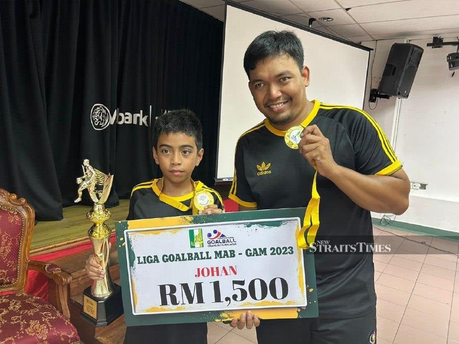  Akif Wirdani (left) with his trophy a teammate after winning the 2023 Malaysian Association For The Blind (MAB) Goalball League. - NSTP/ Ainun Jariah