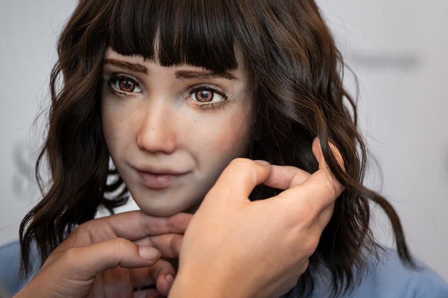 A staff sets the wig of healthcare assistant robot "Grace" at the booth of SingularityNET company during the world's largest gathering of humanoid AI Robots as part of International Telecommunication Union (ITU) AI for Good Global Summit in Geneva. - AFP PIC