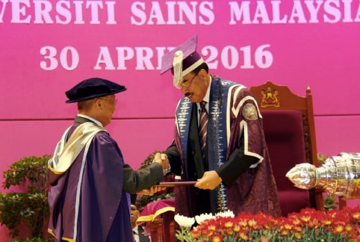  Universiti Sains Malaysia's Pro-Chancellor Tan Sri Mustafa Mansur (right) presents the honorary degree (Doctor of Management) to AmBank Group chairman Tan Sri Azman Hashim during the 53rd Convocation ceremony. Pix by MUHAMMAD MIKAIL ONG. 