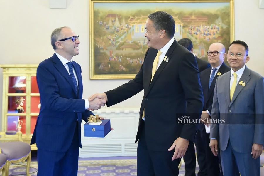 Thailand's Prime Minister Srettha Thavisin (C) shaking hands with Stefano Domenicali (L), president and CEO of the Formula One Group, during a meeting in Bangkok.-AFP PIC