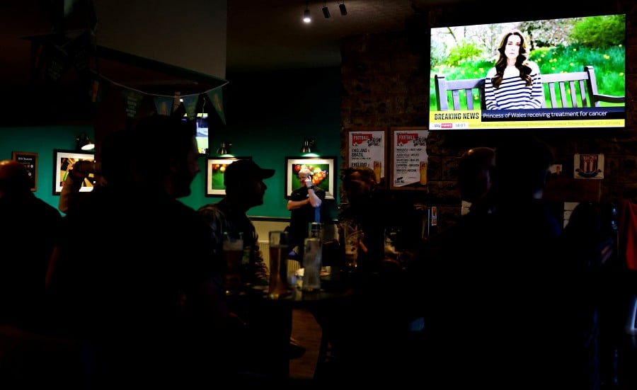 People watch Sky News in The Thistleberry Hotel, as a video is shown in which Britain's Catherine, Princess of Wales, announced she is undergoing preventative chemotherapy after tests taken following abdominal surgery in January revealed cancer had been present, in Newcastle. - REUTERS PIC