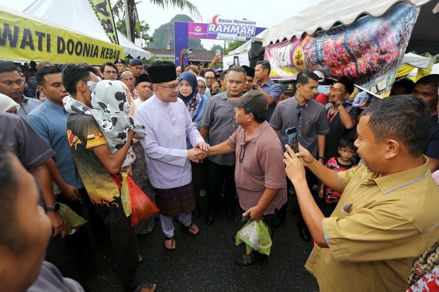 Prime Minister Datuk Seri Anwar Ibrahim mingles with the crowd while visiting the Taman Perpaduan Ulu Kinta Ramadan Bazaar in Ipoh on March 25, 2024. - BERNAMA PIC