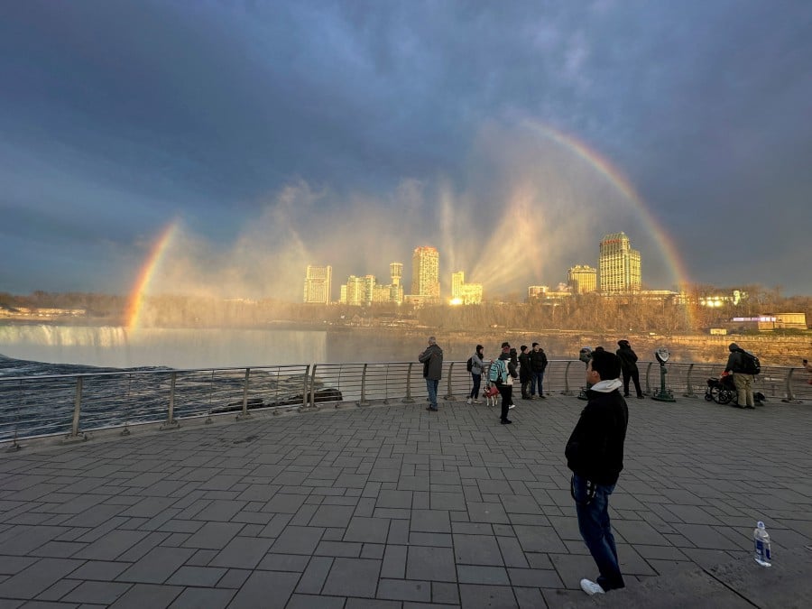 Rainbow forms over Niagara Falls as people wait for a solar eclipse at Niagara Falls in New York. - REUTERS PIC