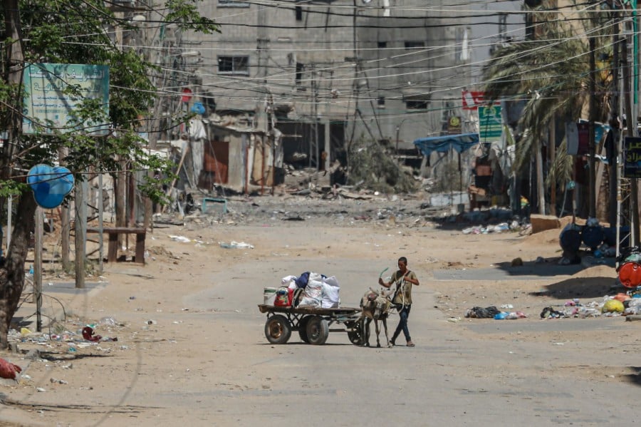 A man with his belongings loaded on a cart flees the city of Nuseirat in the central Gaza Strip. - AFP PIC