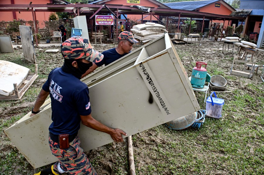 Firemen help clean Sekolah Kebangsaan Pasir Raja which was hit by the recent floods in Dungun. - BERNAMA PIC