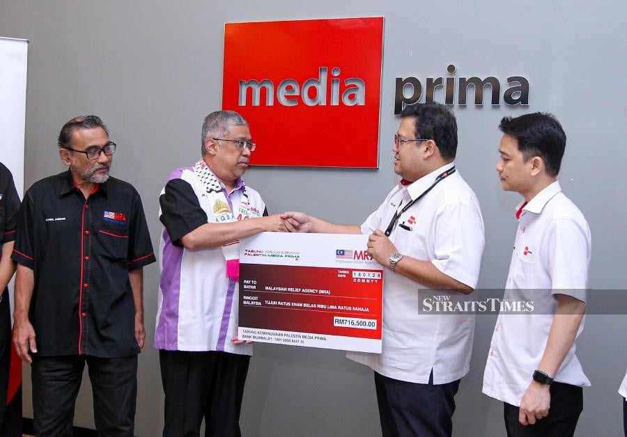 Media Prima Bhd (MPB) group corporate communication general manager Azlan Abdul Aziz (2nd right) handing over a mock cheque to the Malaysian Relief Agency (MRA) president Dr Mohd Daud Sulaiman (2nd left), during the ceremony at Balai Berita, Bangsar. - NSTP/AZIAH AZMEE
