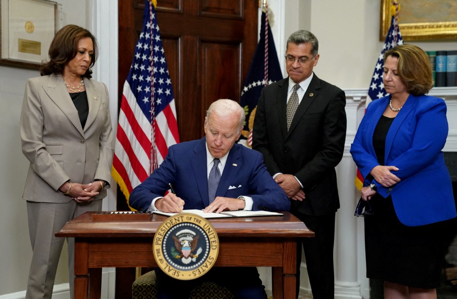  U.S. President Joe Biden signs an executive order to help safeguard women's access to abortion and contraception after the Supreme Court last month overturned Roe v Wade decision that legalised abortion, as Vice President Kamala Harris, Health and Human Services Secretary Xavier Becerra and Deputy Attorney General Lisa Monaco stand at his side at the White House in Washington, U.S., July 8, 2022. -- REUTERS PIC