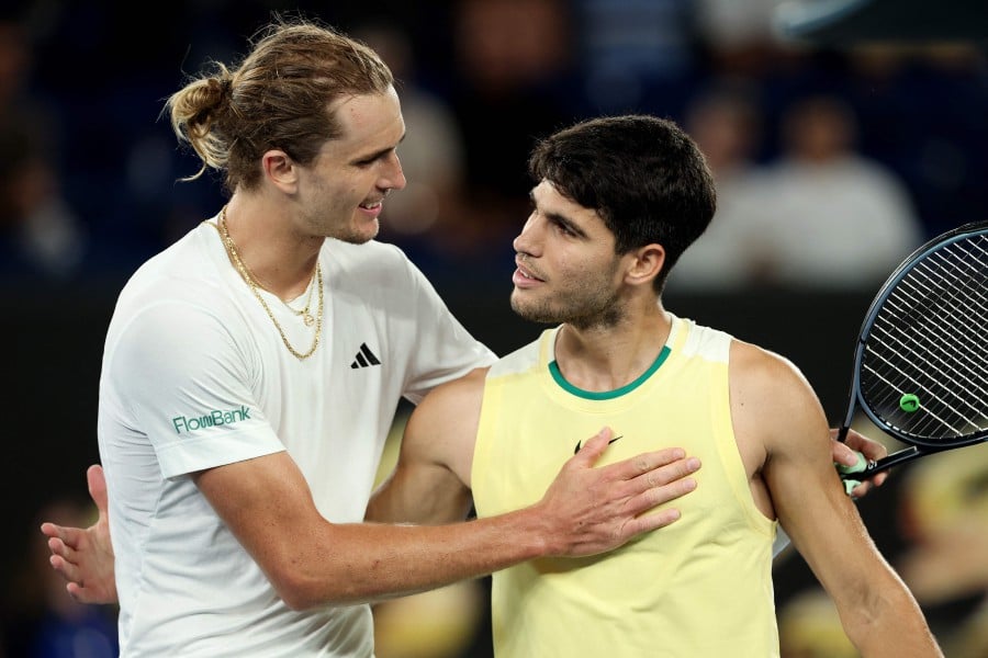 Germany's Alexander Zverev (L) embraces Spain's Carlos Alcaraz after their men's singles quarter-final match on day 11 of the Australian Open tennis tournament in Melbourne. - AFP PIC