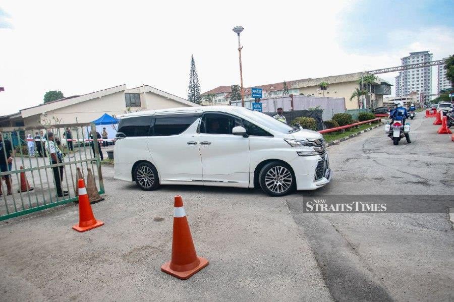 A car is seen leaving with the remains of the victim at the Tengku Ampuan Rahimah Hospital. -NSTP/GENES GULITAH