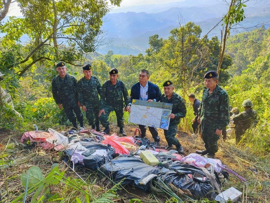 Members of the Pha Muang Task Force and Thai security personnel with confiscated bags of amphetamine tablets, following a clash with suspected drug traffickers in Chiang Rai province's Mae Fah Luang district in northern Thailand.-AFP PIC