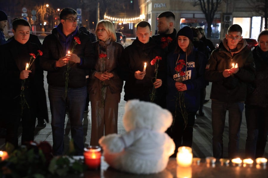 People lay flowers and lit candles in memory of the Moscow concert gun attack victims in the centre of Simferopol, Crimea. - AFP PIC