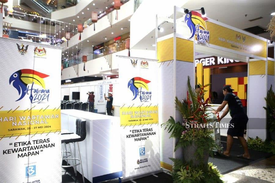 Workers applying final touches ahead of the 2024 National Journalists’ Day (HAWANA) celebration in Plaza Merdeka shopping centre, in Kuching. - NSTP/NADIM BOKHARI