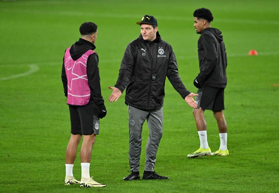Dortmund's German head coach Edin Terzic (Center) talks with Dortmund's English forward Jadon Sancho during a training session at the Phillips stadium in Eindhoven back in February. — AFP