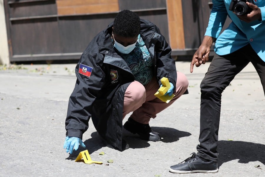 Members of the Haitian police and forensics look for evidence outside of the presidential residence on July 7, 2021 in Port-au-Prince, Haiti. -AFP Pic