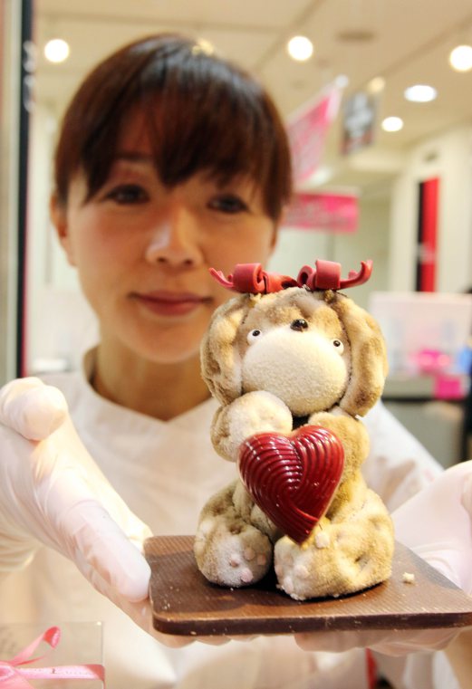 Japanese chocolatier Miya Fujimoto of a sweet shop Etienne displays animal-shaped chocolates at the Takashimaya department store's large chocolate event "Amour du Chocolat" for the upcoming St. Valentine's Day in Tokyo on February 4, 2015. Fujimoto produced two life sized cartoon character chocolate statues, made of 300kg chocolate at the entrance of the department store. AFP PHOTO / Yoshikazu TSUNO