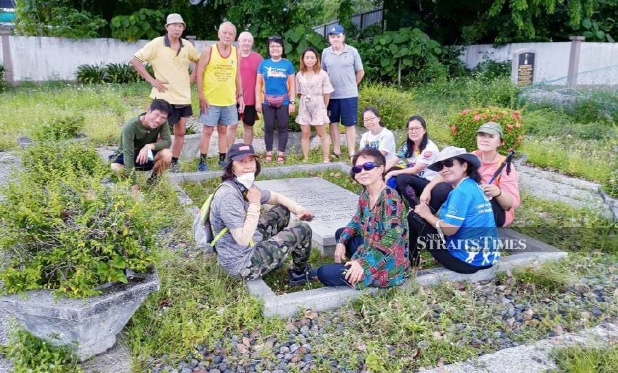 Brig-Gen (Rtd) Datuk Soon Lian Cheng (standing, second from left) with Hash House Harriers from the 'Hash Walk KL' and 'Happy' hikers groups that weeded and spruced up the late Sir Henry Gurney’s grave at the Cheras Christian cemetery in Jalan Kuari, Kuala Lumpur. - NSTP/ADRIAN DAVID