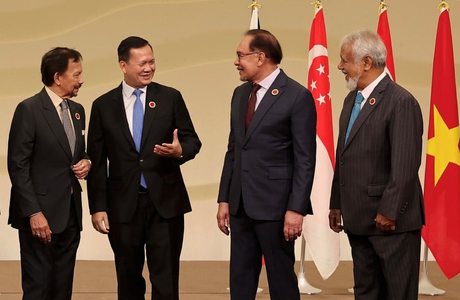 Malaysian Prime Minister Datuk Seri Anwar Ibrahim (third, left) having a light moment with (from left) Sultan Hassanal Bolkiah of Brunei Darussalam, Cambodia Prime Minister Hun Manet and Timor Leste Prime Minister Kay Rala Xanana Gusmao after group photograph with ASEAN leaders during the ASEAN-Japan Commemorative Summit here on Sunday.