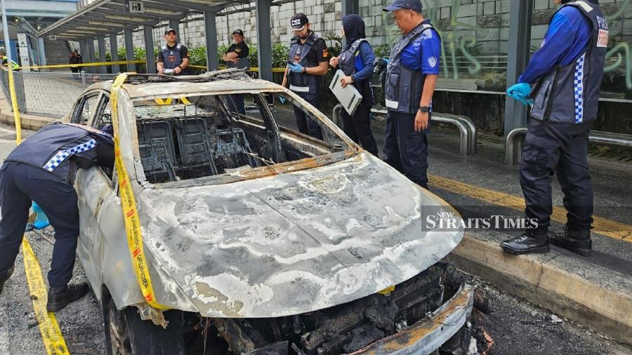 Police personnel carrying out investigation on an auxiliary police car that was set on fire at the Mutiara Damansara MRT station. Photo courtesy of police
