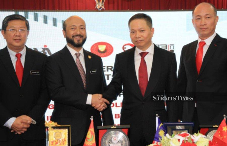 Kedah MB Datuk Seri Mukhriz Mahathir (third from right) shaking hands with Jin Yeuhua (second from right) at a signing ceremony at Wisma Darul Aman today. -NSTP/SHARUL HAFIZ ZAM.. -NSTP/SHARUL HAFIZ ZAM