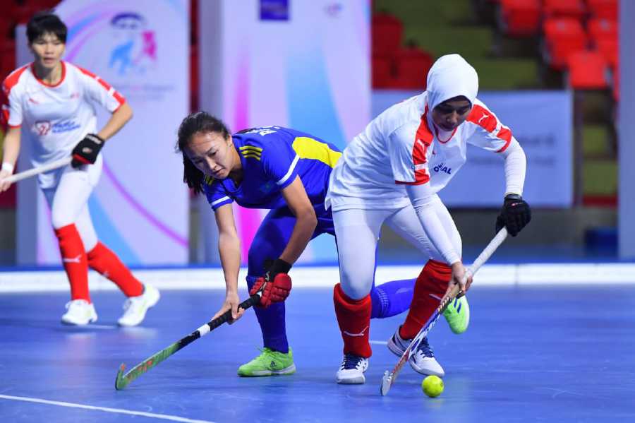 A Malaysian player (right) dribbles past a Kazakhstan player in a women’s indoor Asia Cup match in Bangkok yesterday. - Pic courtesy of MHC