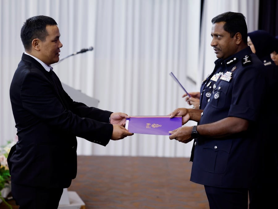 Selangor Police Chief, Datuk Hussein Omar Khan (Right), presents a certificate of appreciation to Nepalese security guard, Sherpa Dewa, 39, following the discovery of RM500,000 in cash inside a luggage bag at a shopping center recently in conjunction with the 217th Police Day Celebration at the Selangor Contingent Police Headquarters (IPK) in Selangor. -- Bernama pic