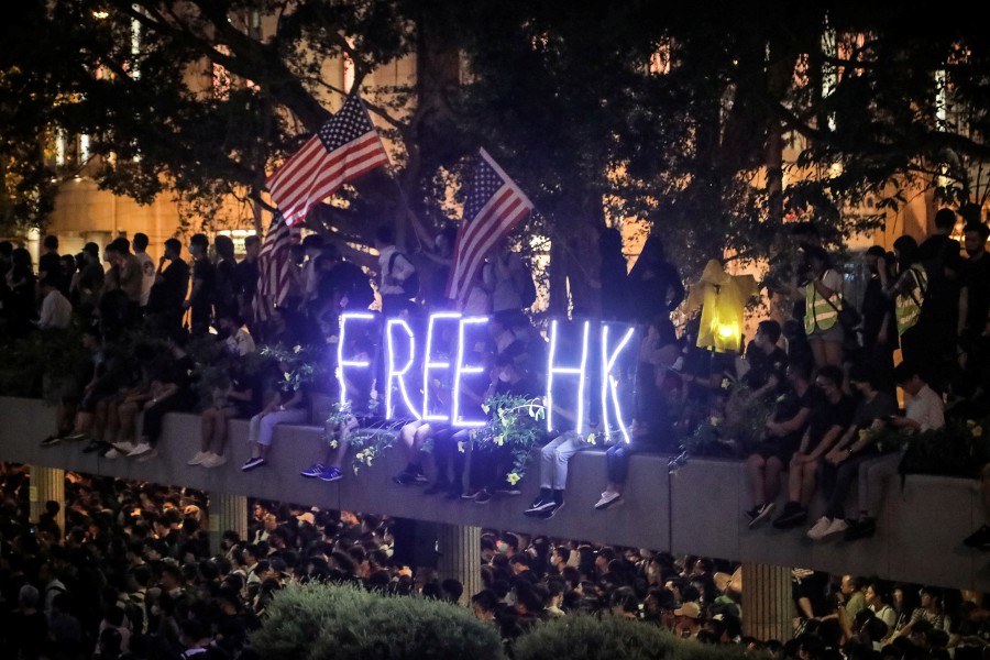  Protesters holding US flags near an illuminated 'Free HK' sign stand at Chater Garden in the Central district in Hong Kong. - EPA