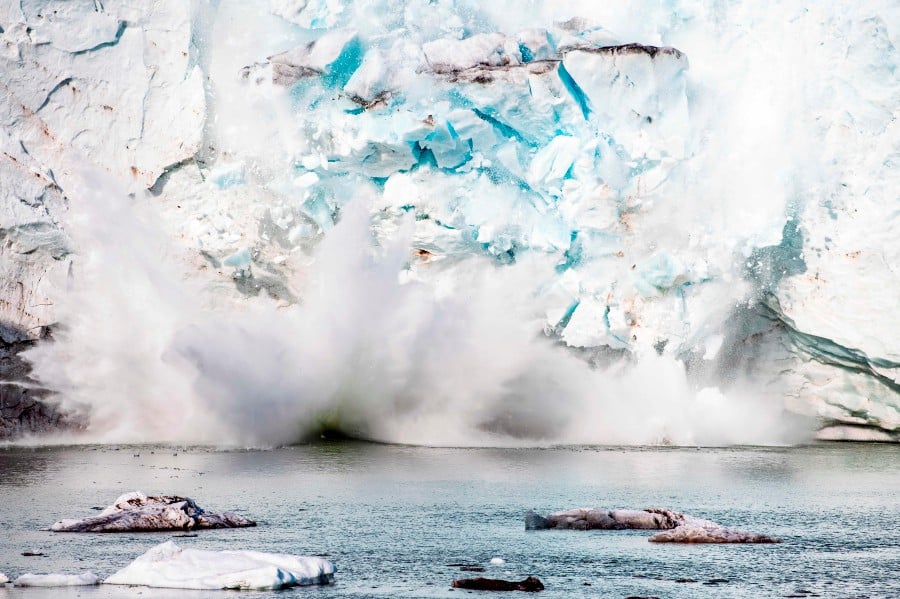 This file photo taken on August 17, 2019 shows an iceberg calving with a mass of ice breaking away from the Apusiajik glacier, near Kulusuk (aslo spelled Qulusuk), a settlement in the Sermersooq municipality located on the island of the same name on the southeastern shore of Greenland. - AFP pic