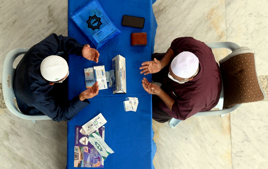 A general view of a person paying zakat at Sultan Salahuddin Abdul Aziz Shah mosque in Shah Alam recently. - BERNAMA PIC